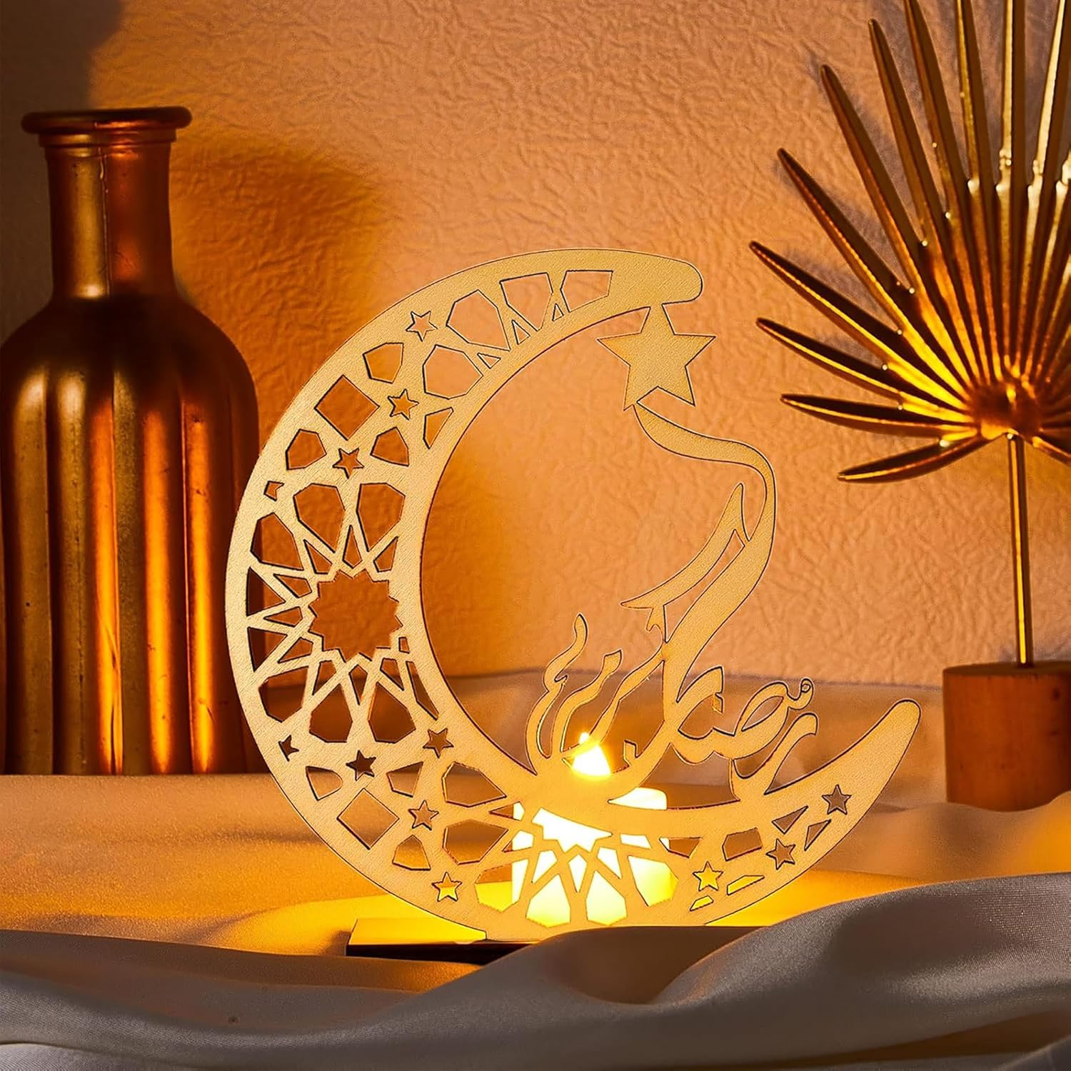 Decorative wooden moon and star lamp with a warm glow, surrounded by decorative items.