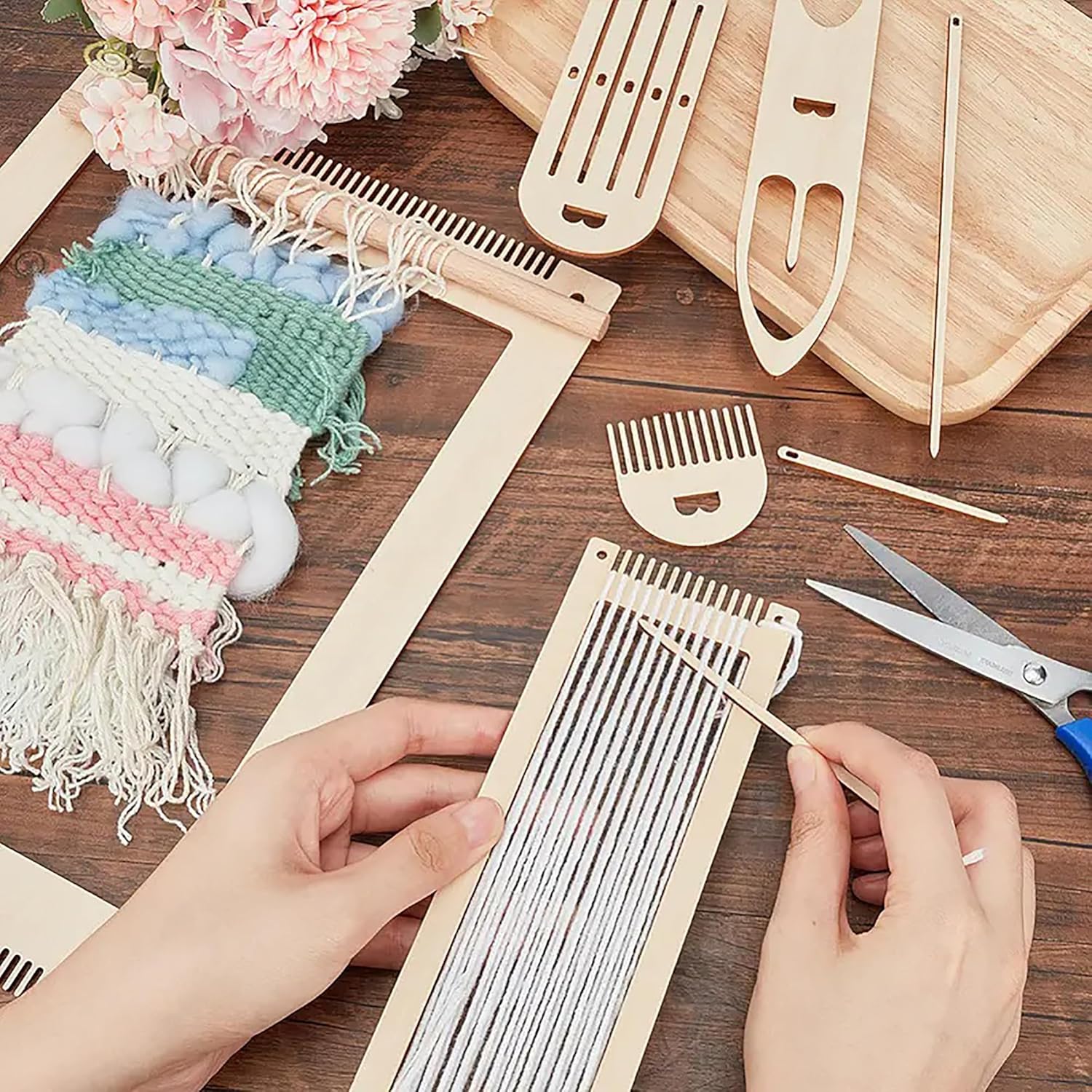 Handmade weaving project with tools and materials on a wooden surface