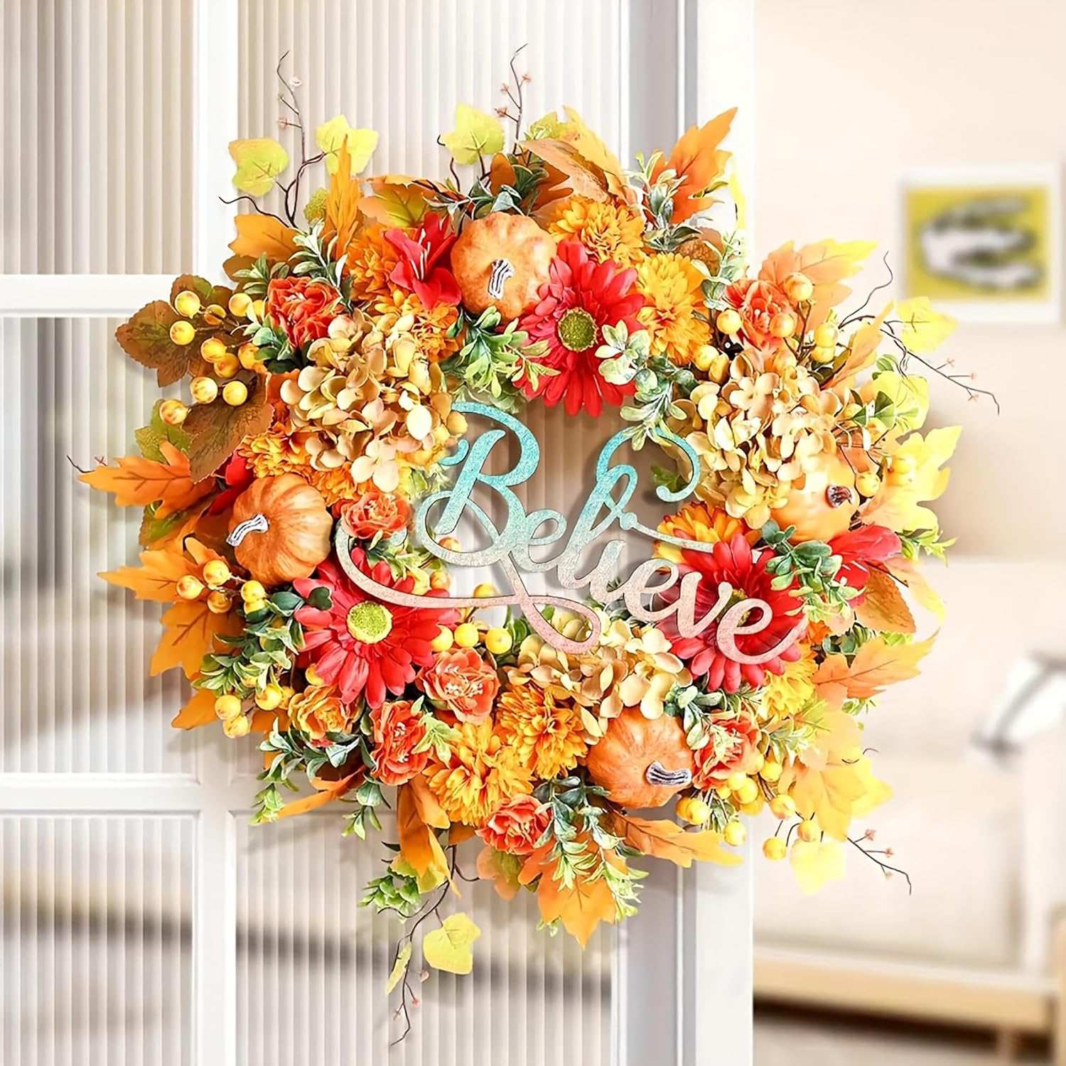 Colorful autumn wreath with pumpkins and 'Believe' text in a home setting.