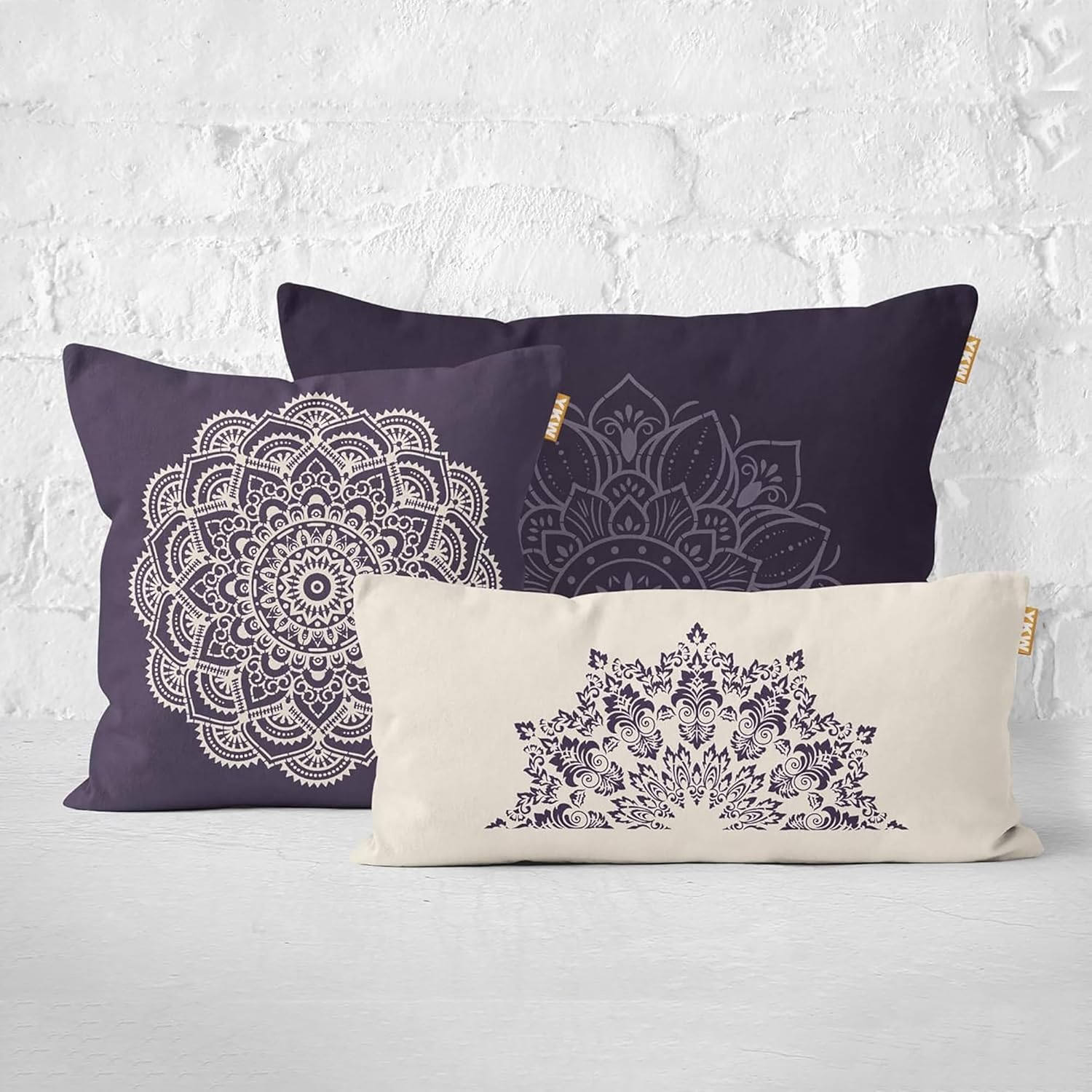 Two pillows with mandala designs on a textured white background