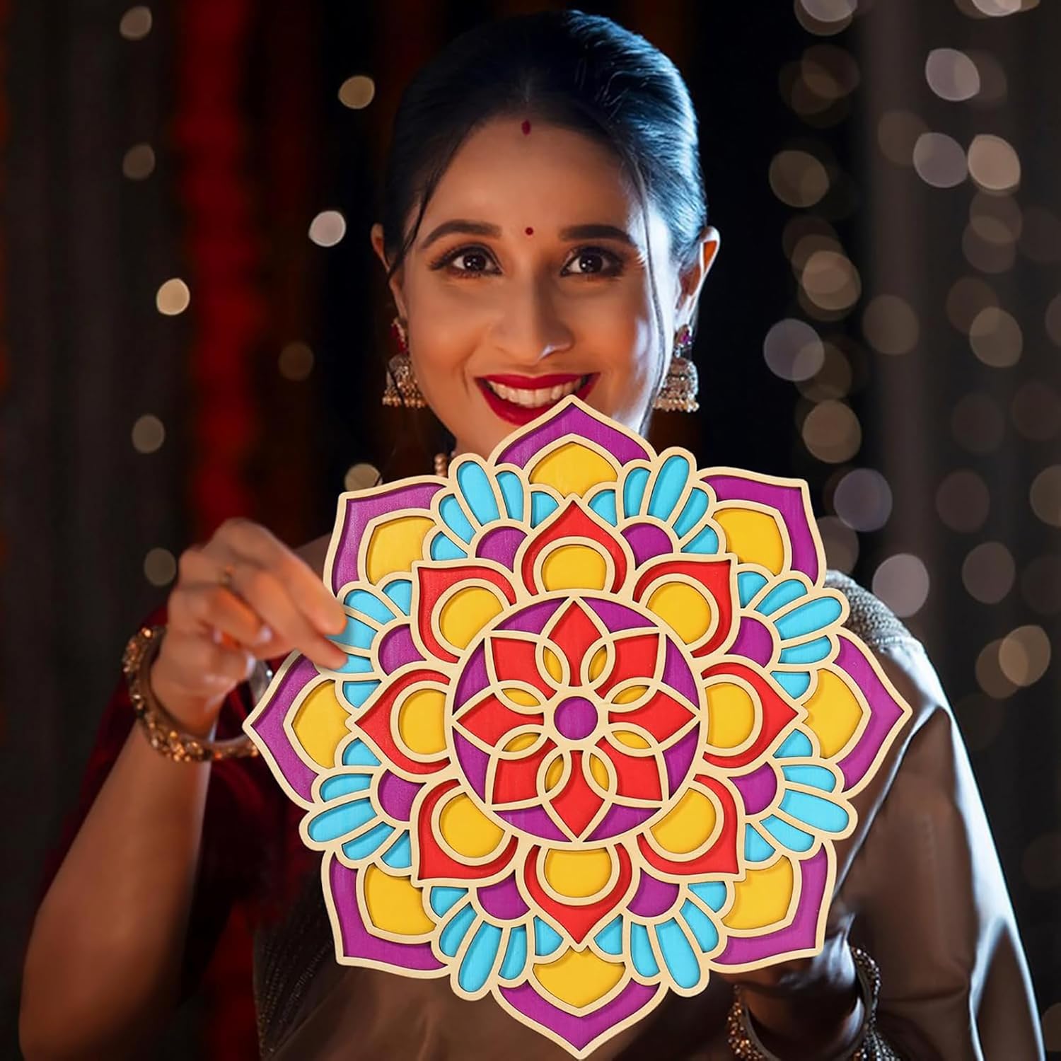 Woman holding a colorful mandala design against a blurred background