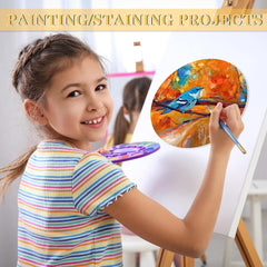 Child painting with a colorful bird on a branch, surrounded by art supplies.
