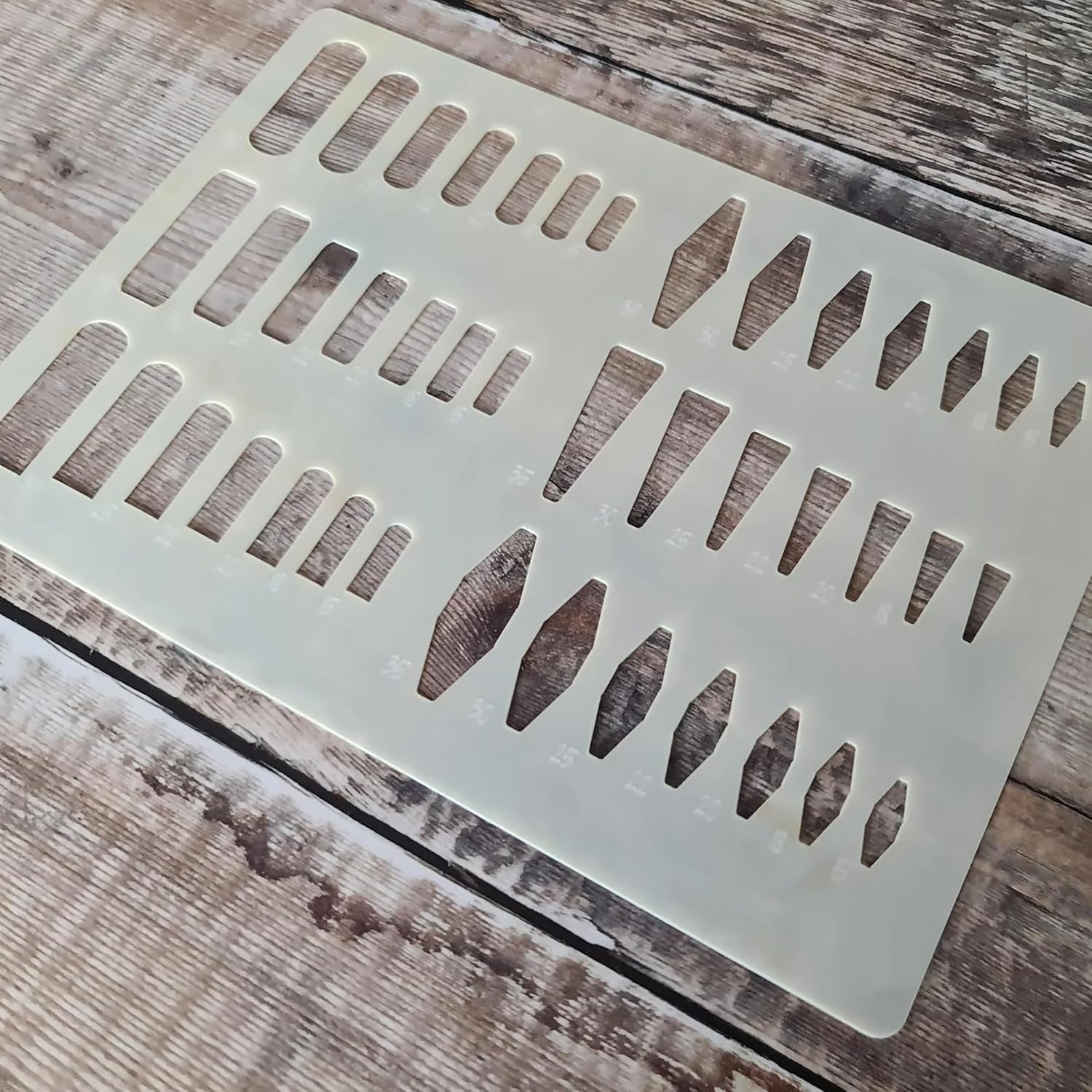 Decorative metal stencil with geometric cutouts on a wooden surface