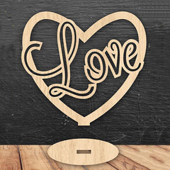 Wooden heart-shaped sign with 'love' text on a dark wooden background
