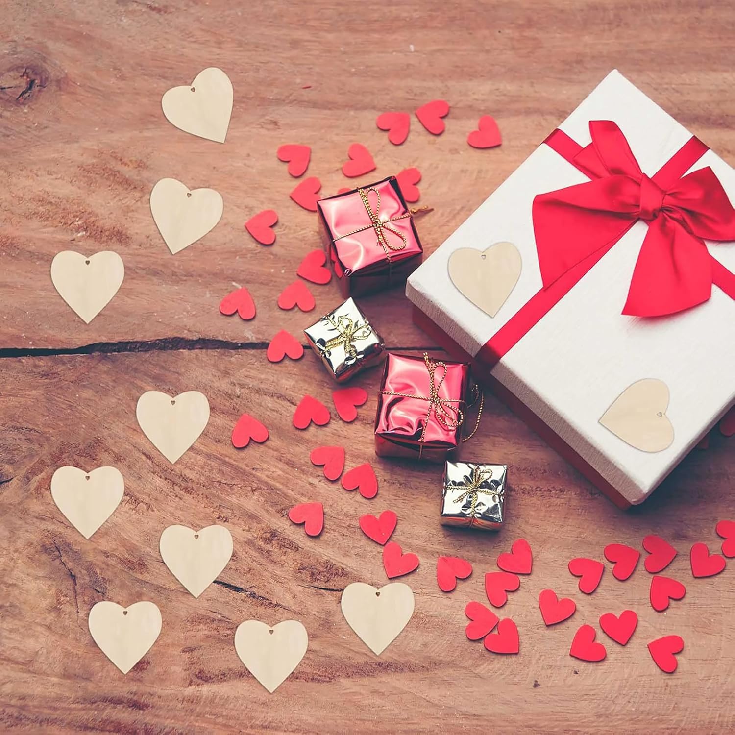 Gift boxes with ribbons and heart-shaped decorations on a wooden surface