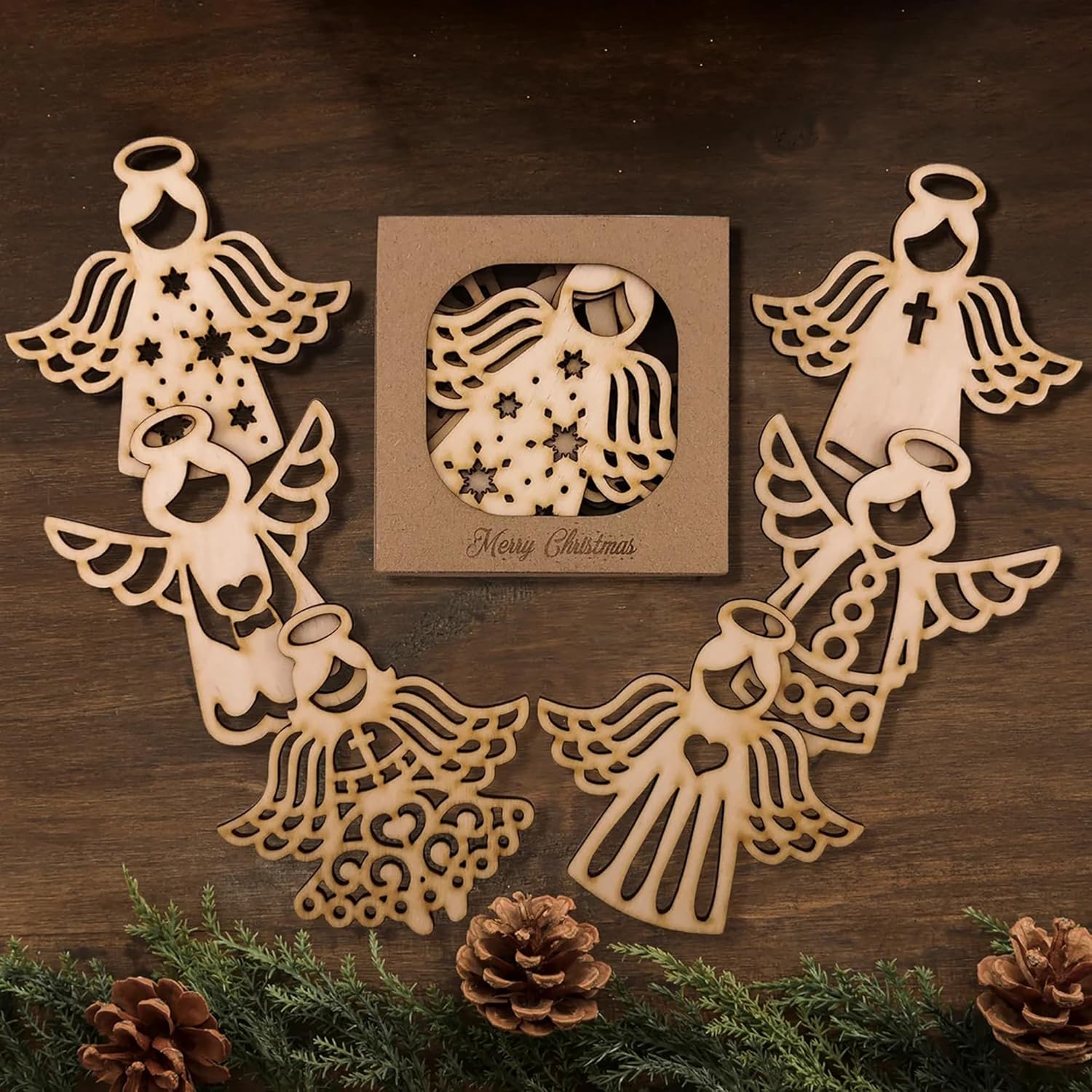 Wooden angel decorations on a wooden surface with a 'Merry Christmas' card.