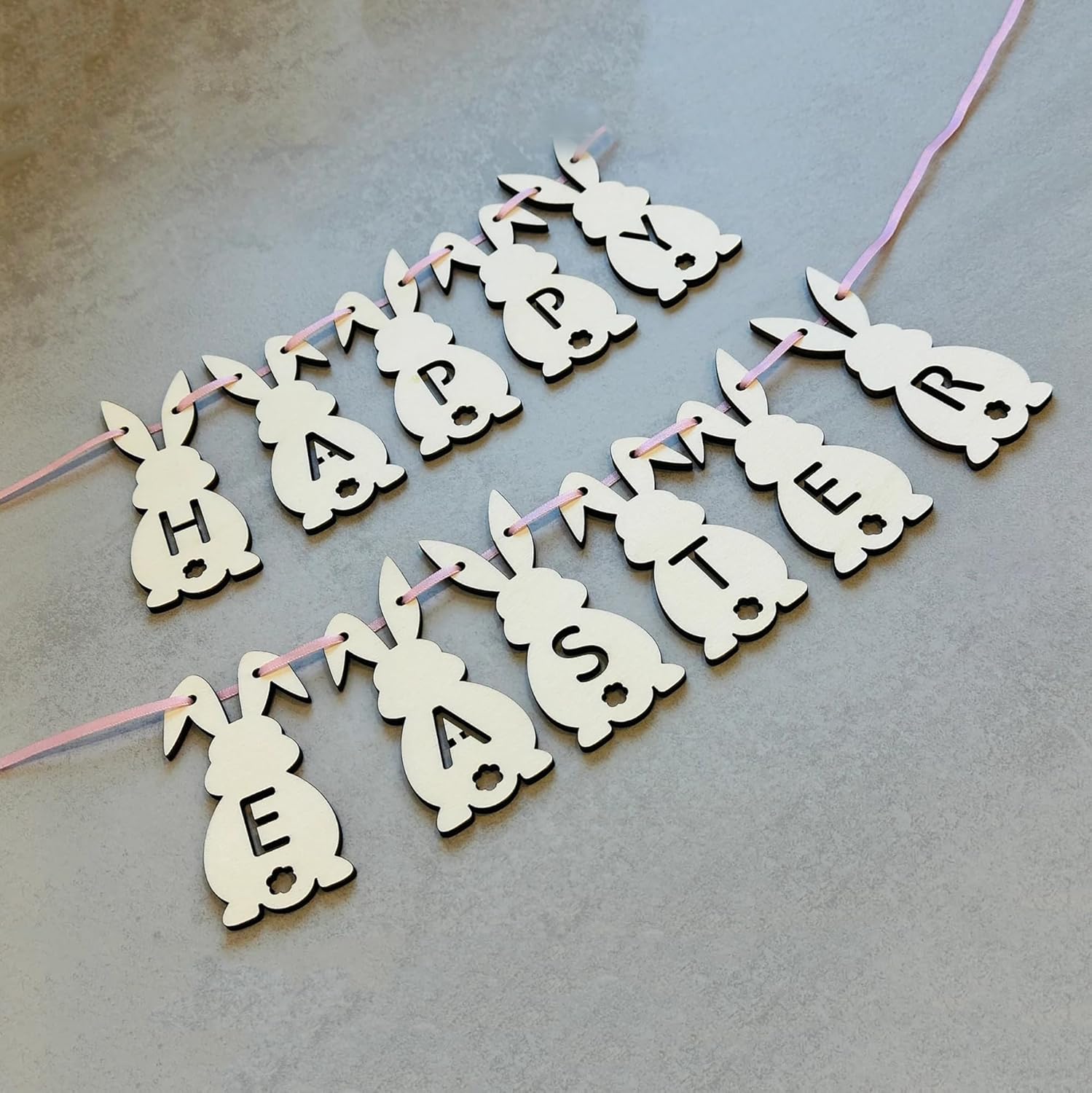 Happy Easter banner with bunny shapes on a gray background