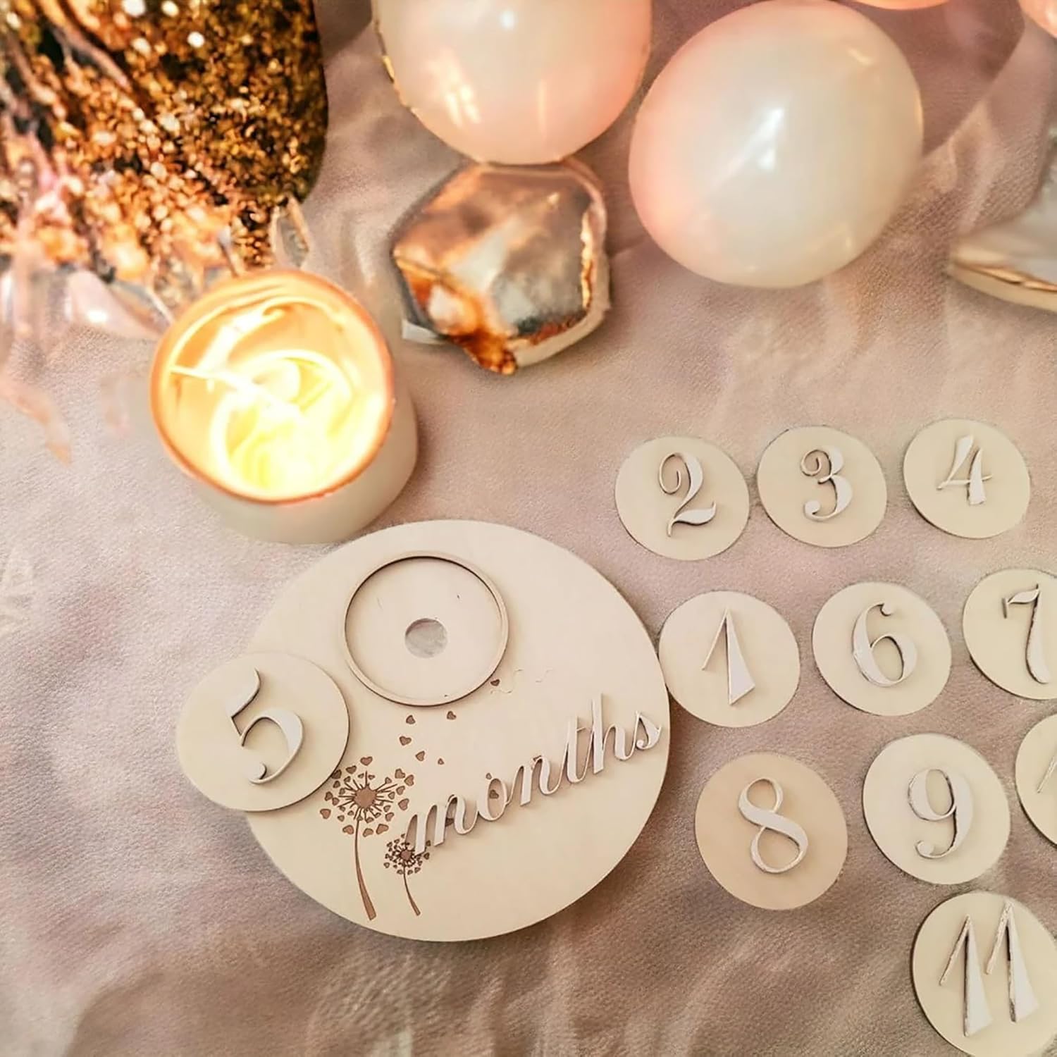 Wooden milestone plaque with '36 months' and decorative numbers on a soft pink background.