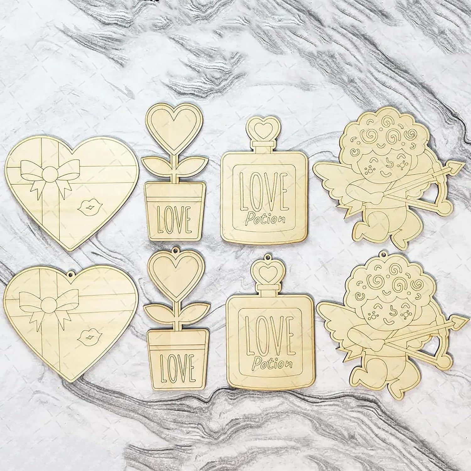 Set of gold-themed decorative items including hearts, plants, and angels on a marble surface.