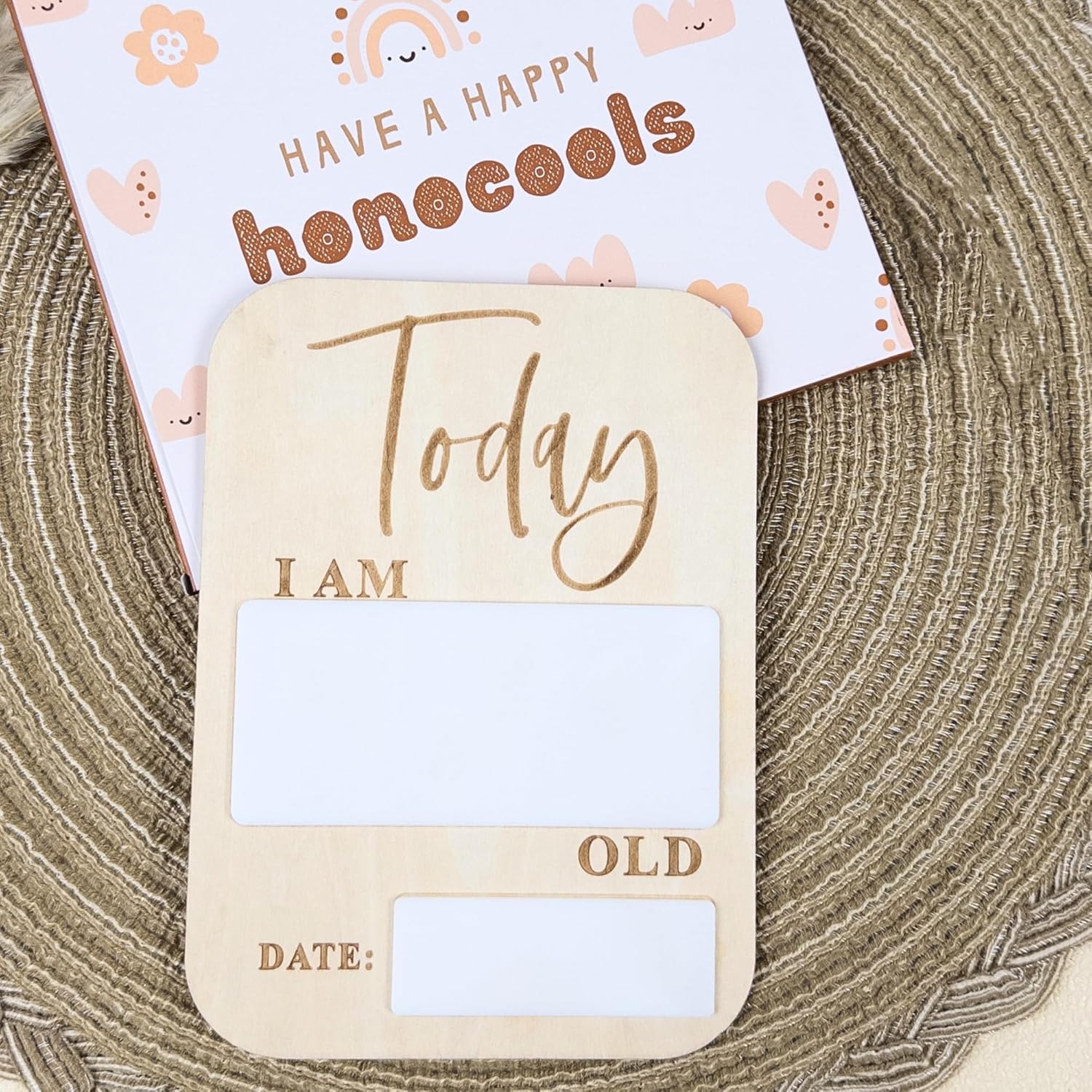 Wooden birthday card with text and blank space for writing age and date on a textured surface.