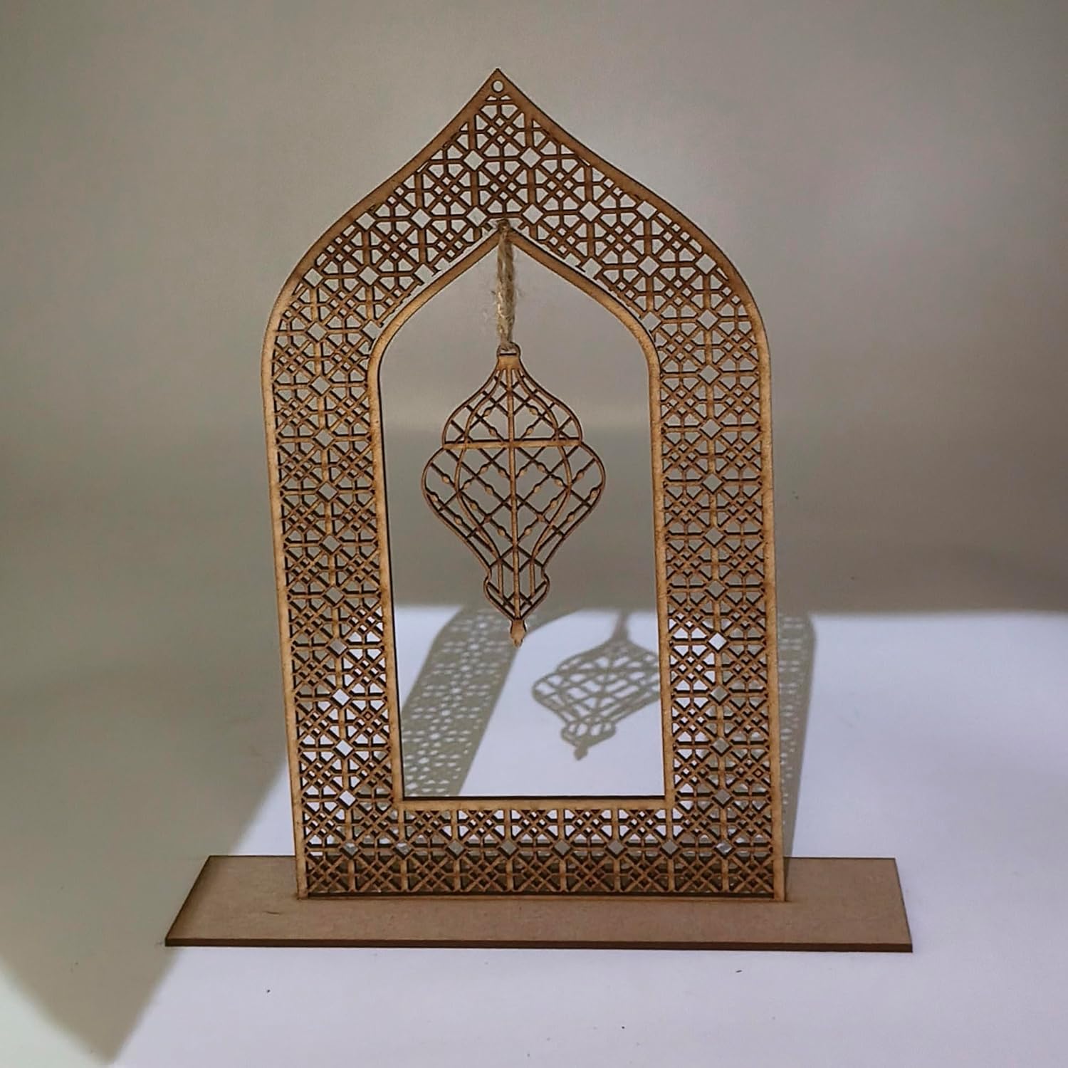 Decorative laser-cut wooden frame with geometric patterns on a plain background