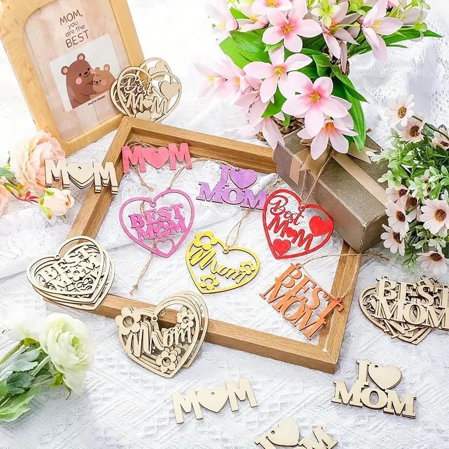 Decorative 'MOM' and 'BEST MOM' signs with flowers on a light surface