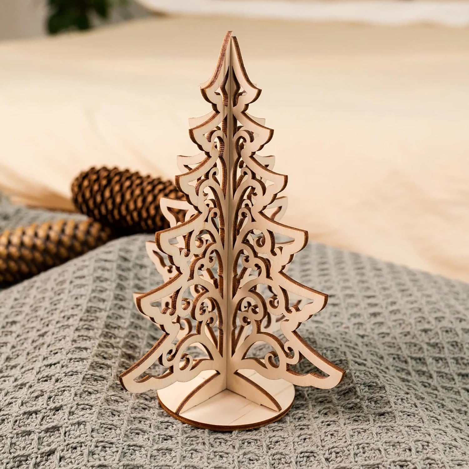 Wooden Christmas tree decoration on a textured surface with a blurred background