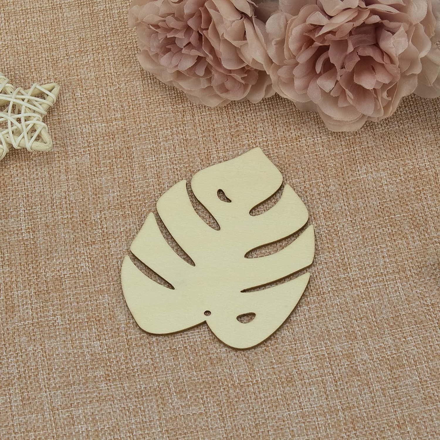 Decorative leaf-shaped item on a textured fabric background with flowers.