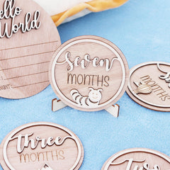 Wooden milestone discs with engraved text on a blue background
