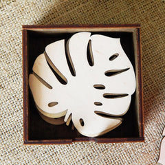 Wooden leaf-shaped coaster set in a wooden box on a textured surface
