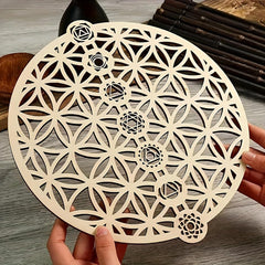 Geometric wooden cutout with intricate patterns held by hands on a wooden surface