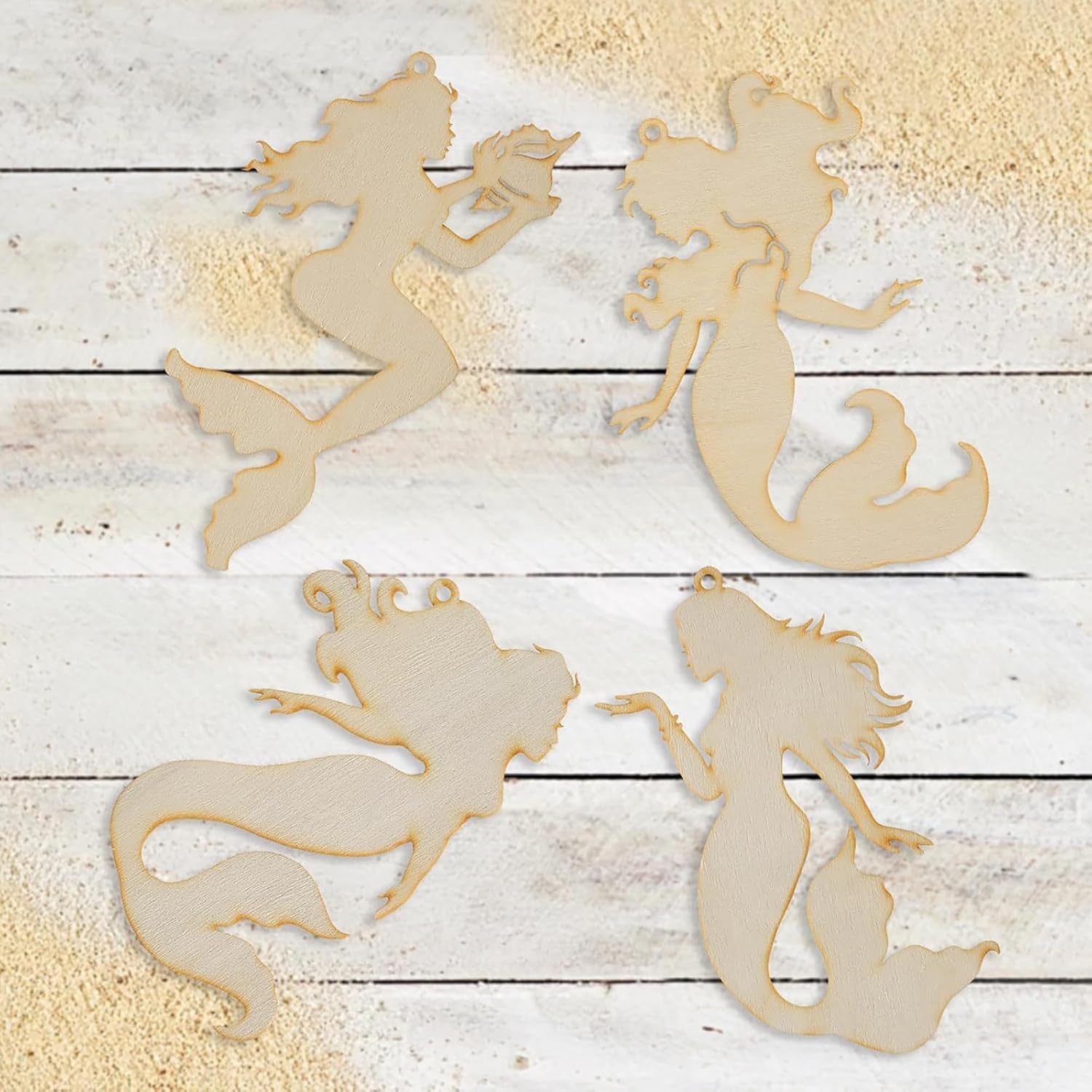 Four wooden mermaid silhouettes on a wooden surface