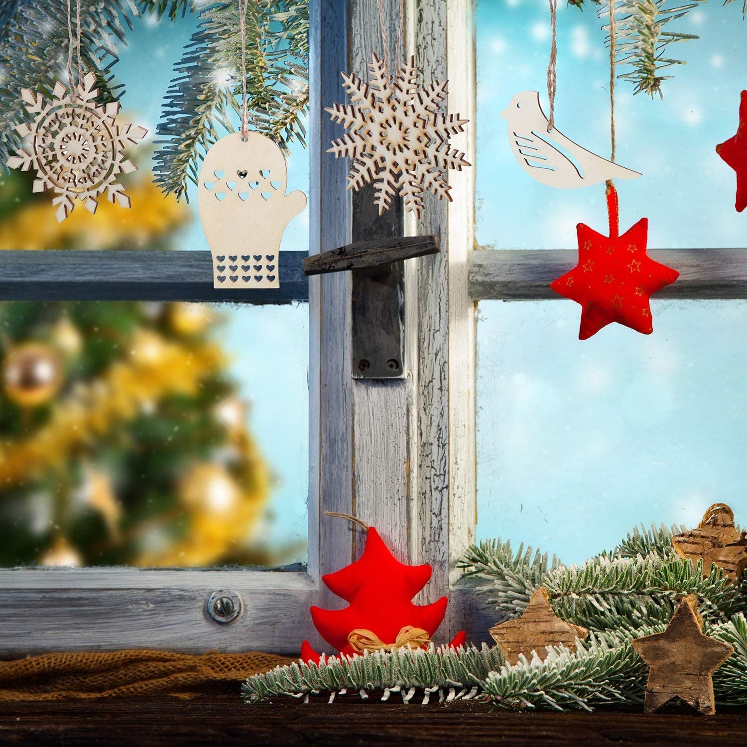 Decorative Christmas ornaments on a rustic wooden window sill with a blurred festive background.