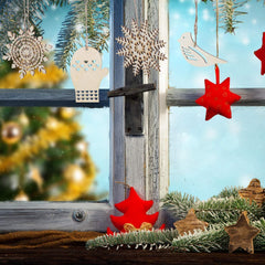 Decorative Christmas ornaments on a rustic wooden window sill with a blurred festive background.