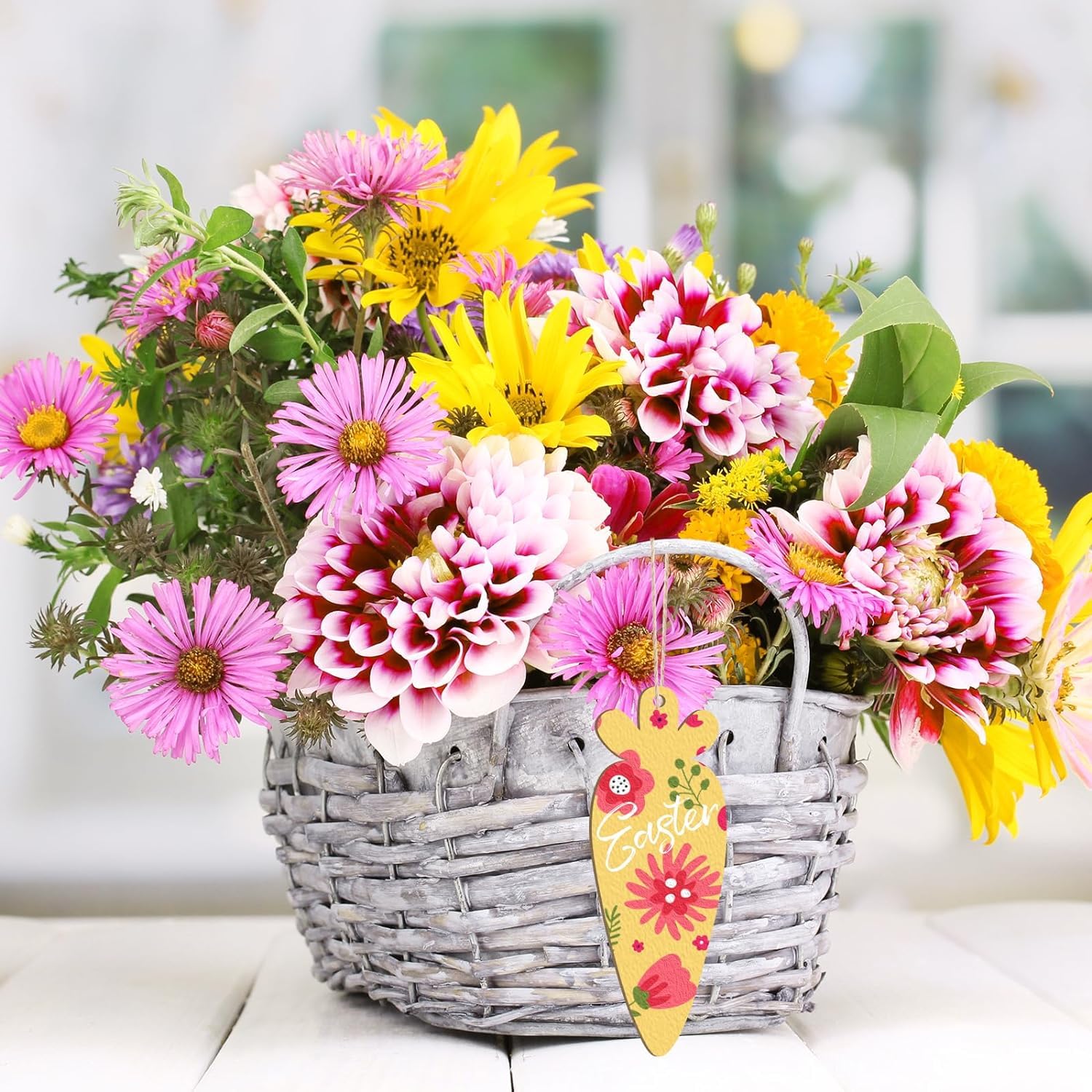 Bouquet of colorful flowers in a wicker basket with a decorative tag on a light background