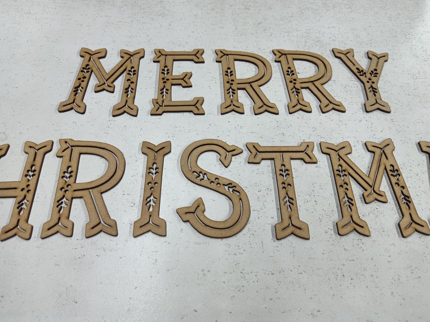 Wooden 'Merry Christmas' decoration on a light background