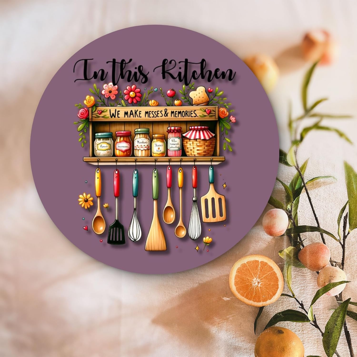 Decorative plate with kitchen utensils and text 'In this Kitchen We Make Messes & Memories' on a floral background.