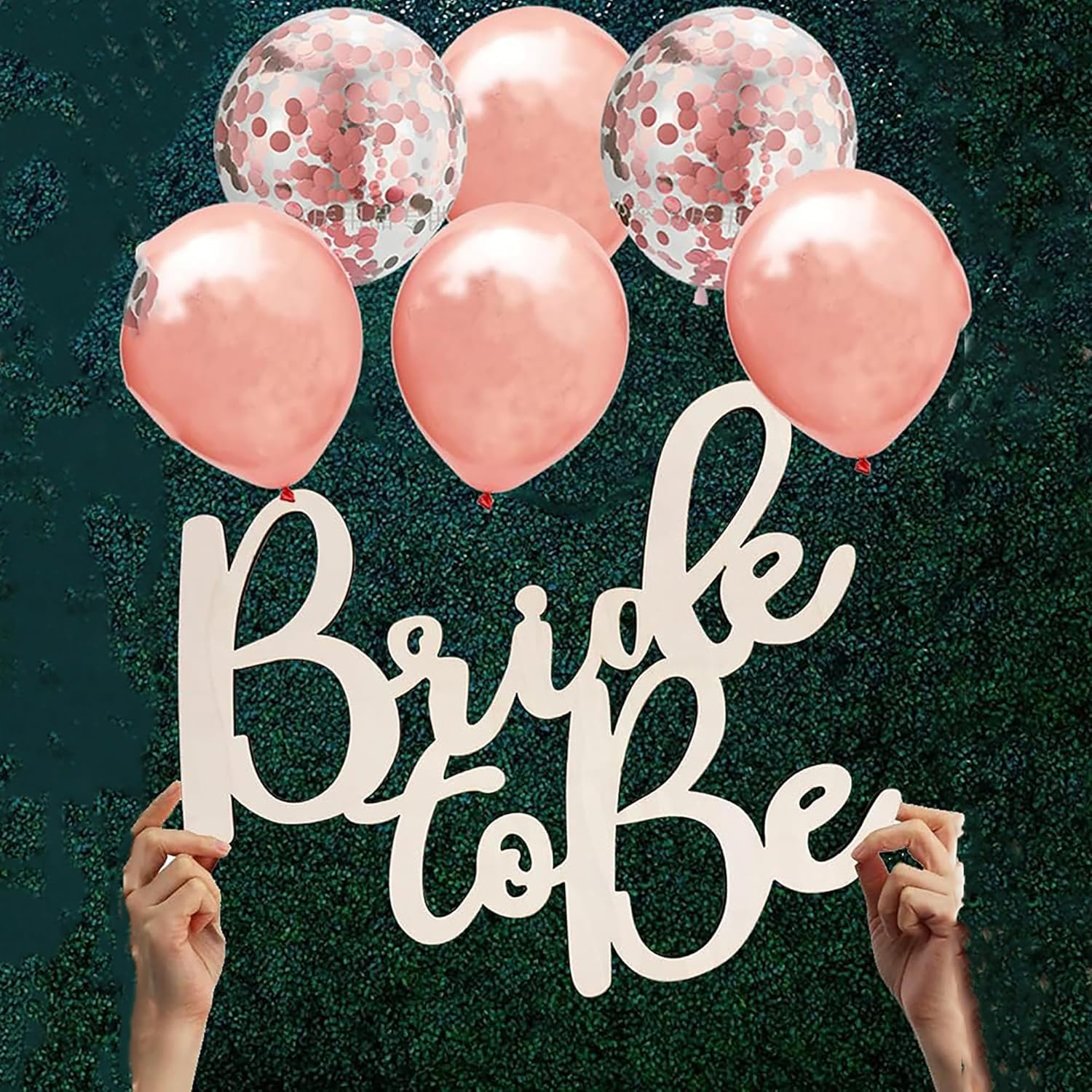 Rose gold balloons with 'Bride to be' sign against a dark background