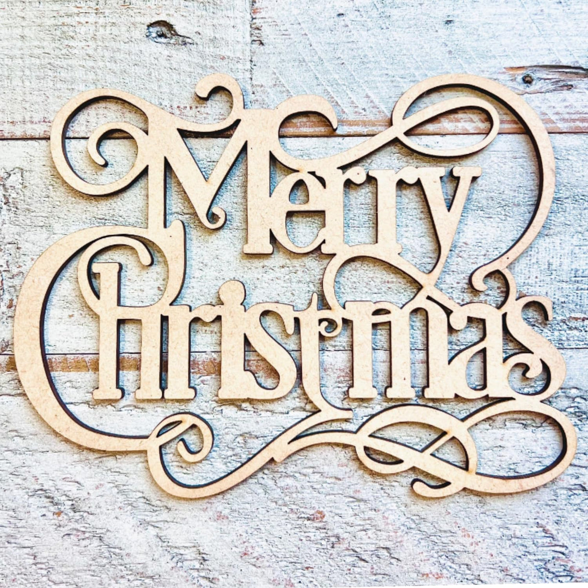 Wooden 'Merry Christmas' decoration on a rustic wooden background