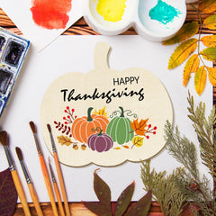 Painting of pumpkins and 'Happy Thanksgiving' text on a wooden board with watercolor paints and brushes.