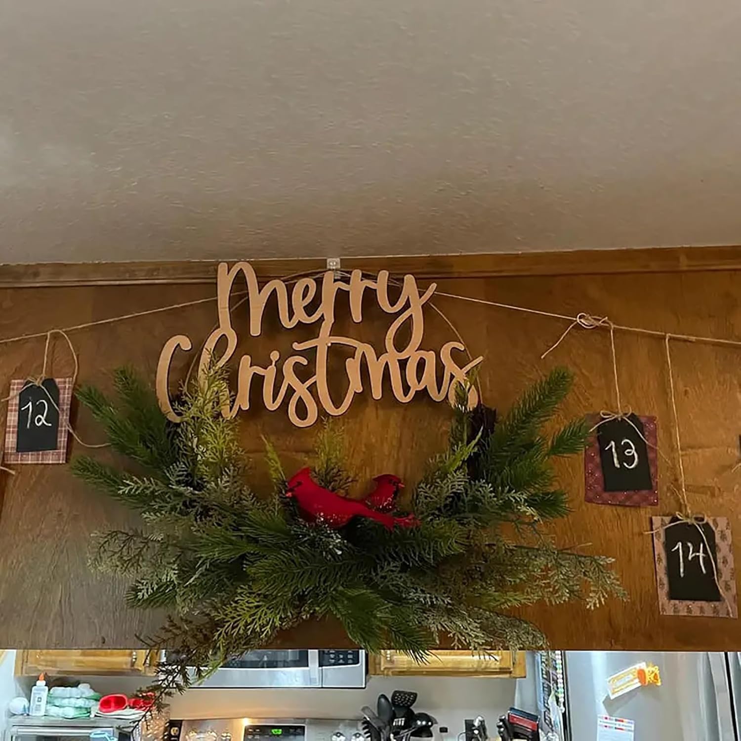Decorative Christmas sign with 'Merry Christmas' on a wooden board with greenery and small red birds.