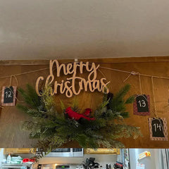 Decorative Christmas sign with 'Merry Christmas' on a wooden board with greenery and small red birds.
