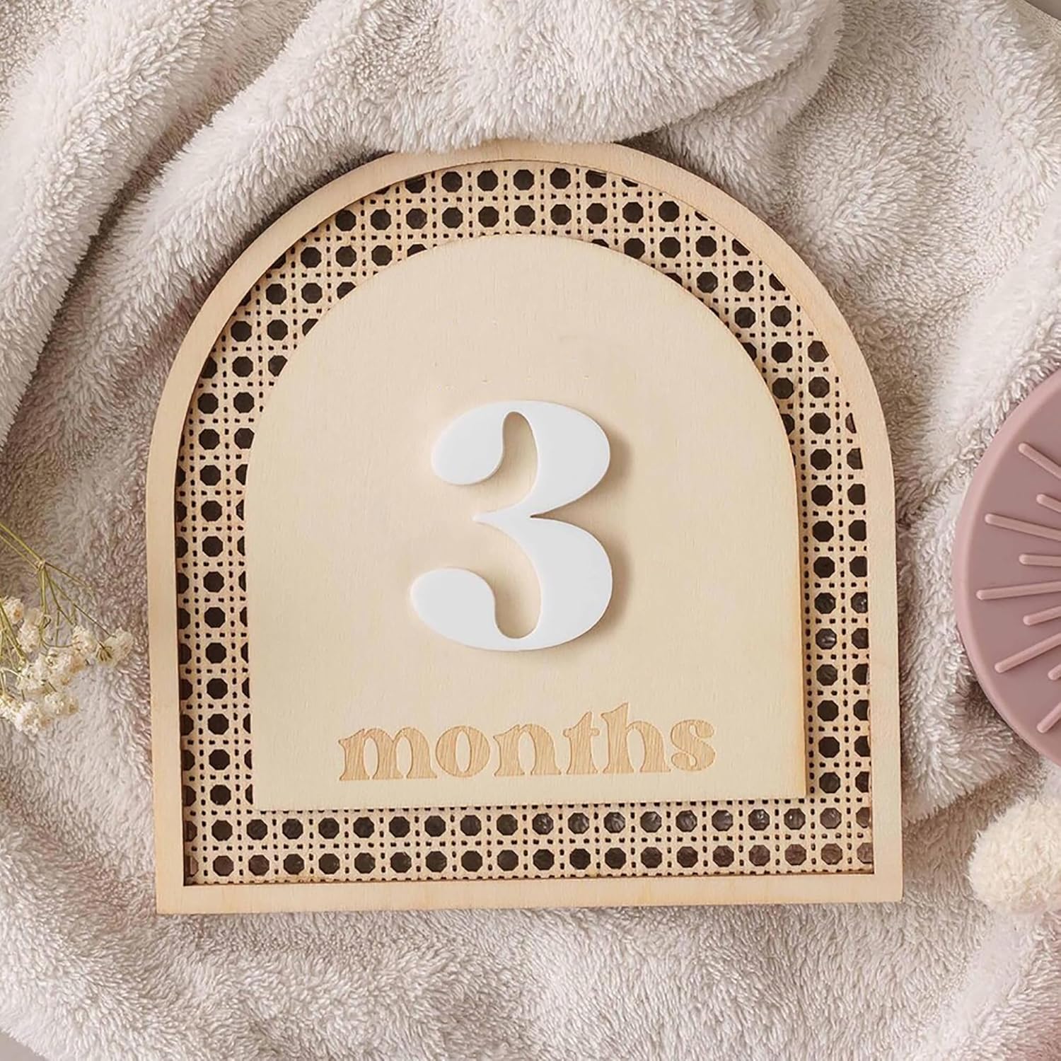 Baby milestone board with '3 months' on a soft fabric background