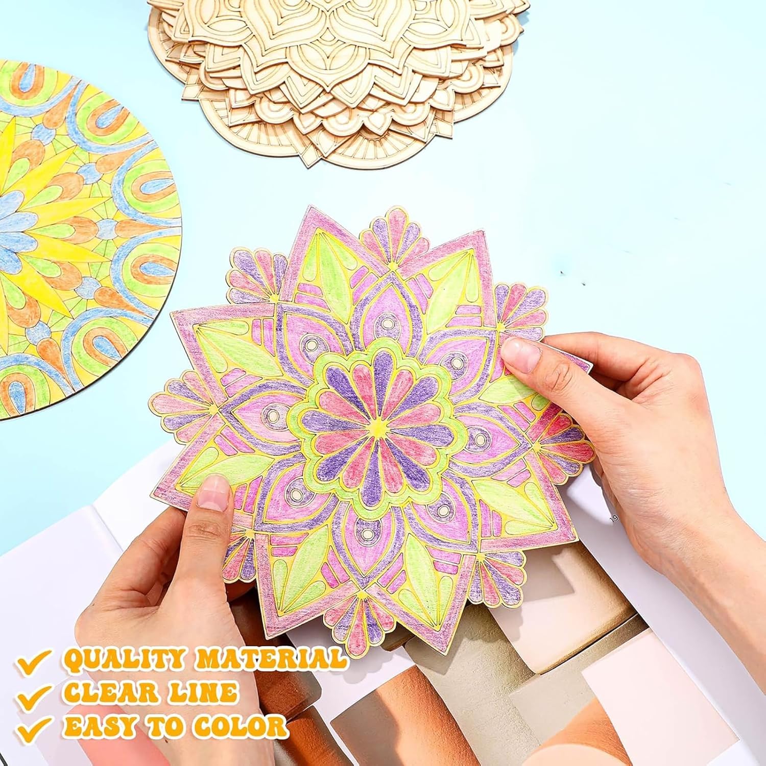 Colorful mandala design being held by hands with other mandalas in the background.