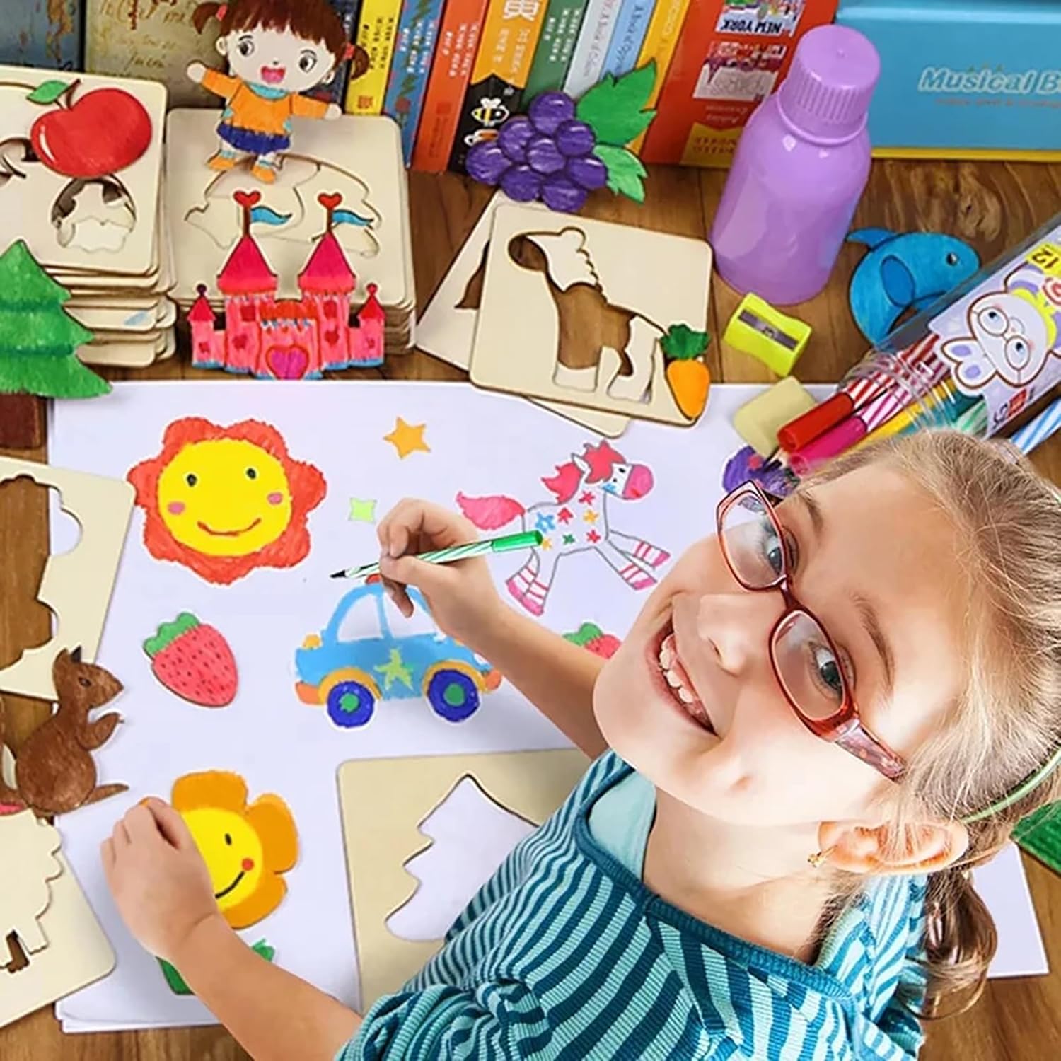 Child coloring with crayons on a table with educational toys and books.