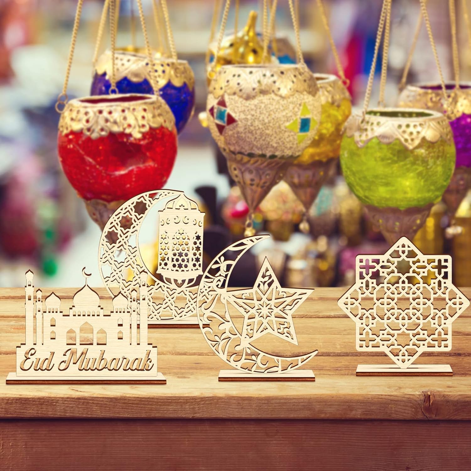 Decorative items including colorful hanging lanterns and wooden 'Eid Mubarak' signs on a wooden surface.