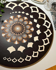 Decorative round table with intricate black and white pattern on a white surface