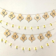 Decorative banner with 'Ramadan Kareem' text and string lights on a white wall.