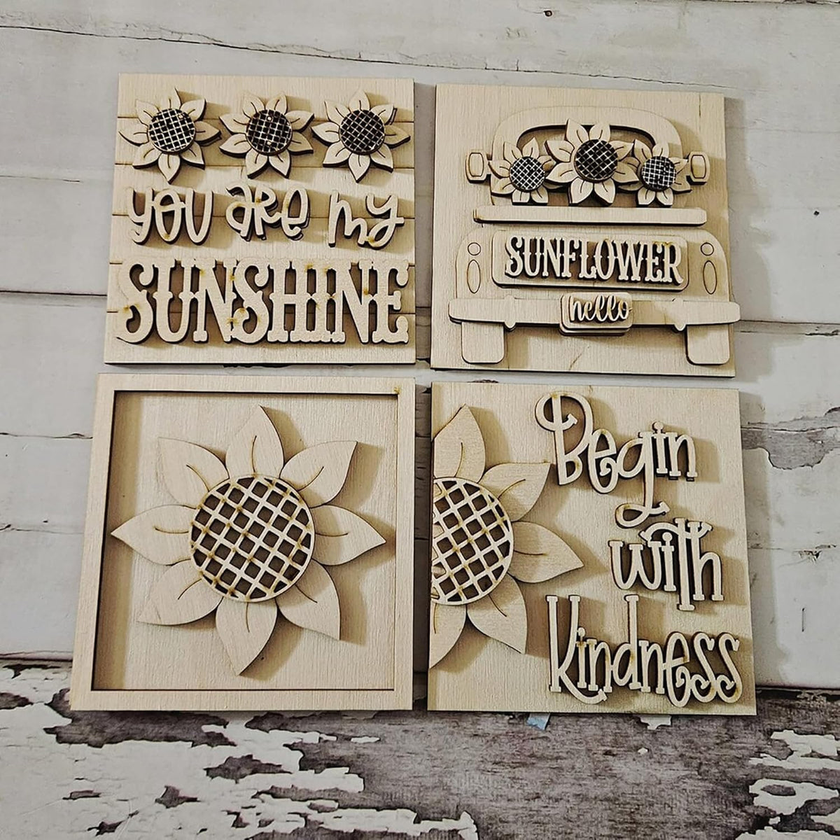 Wooden wall art pieces with sunflower designs and text on a rustic wooden background.