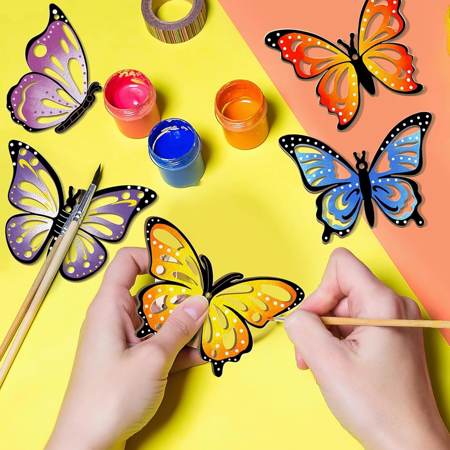 Butterfly-shaped craft items with paint and brushes on a colorful background