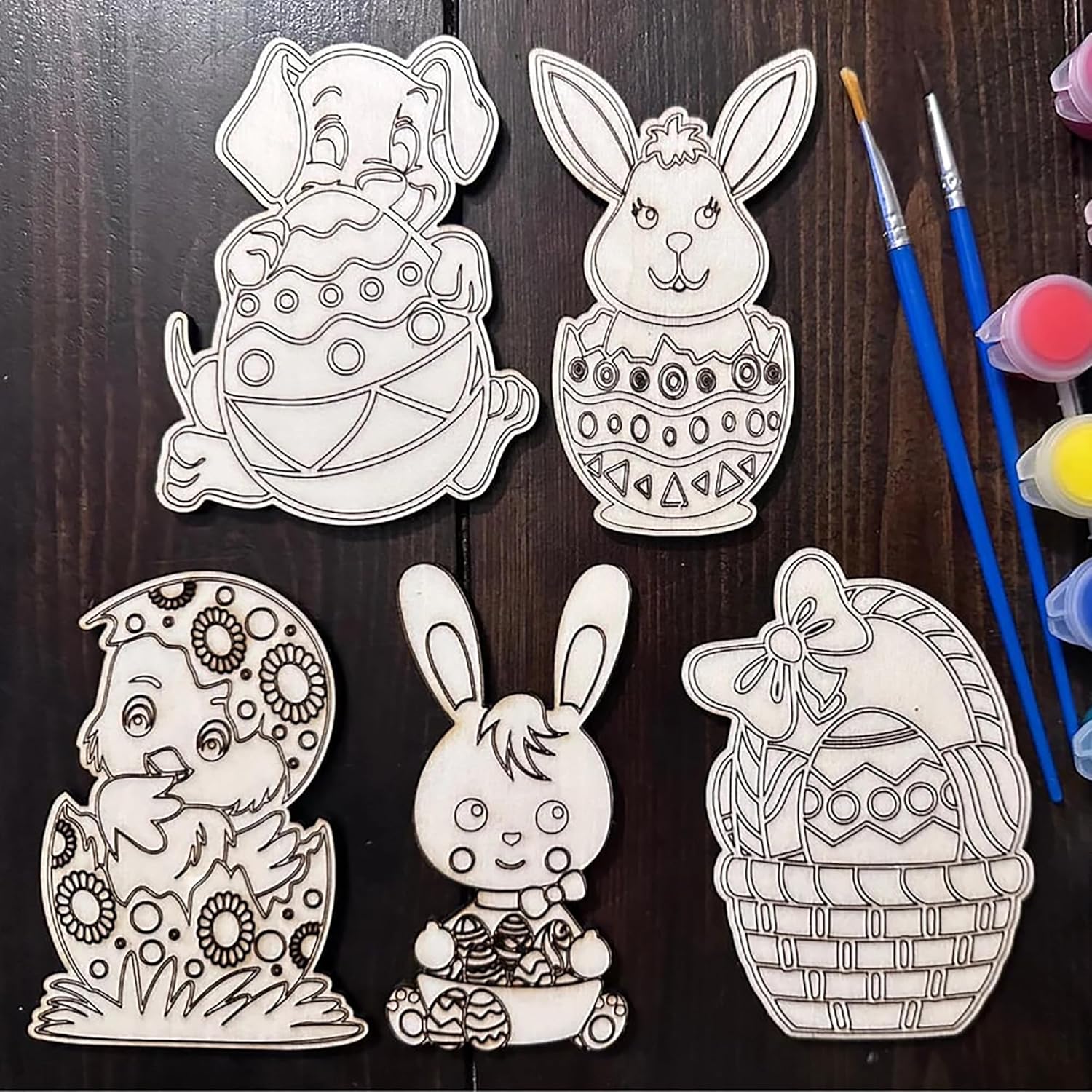 Set of Easter-themed coloring pages with paintbrushes and paint on a wooden surface