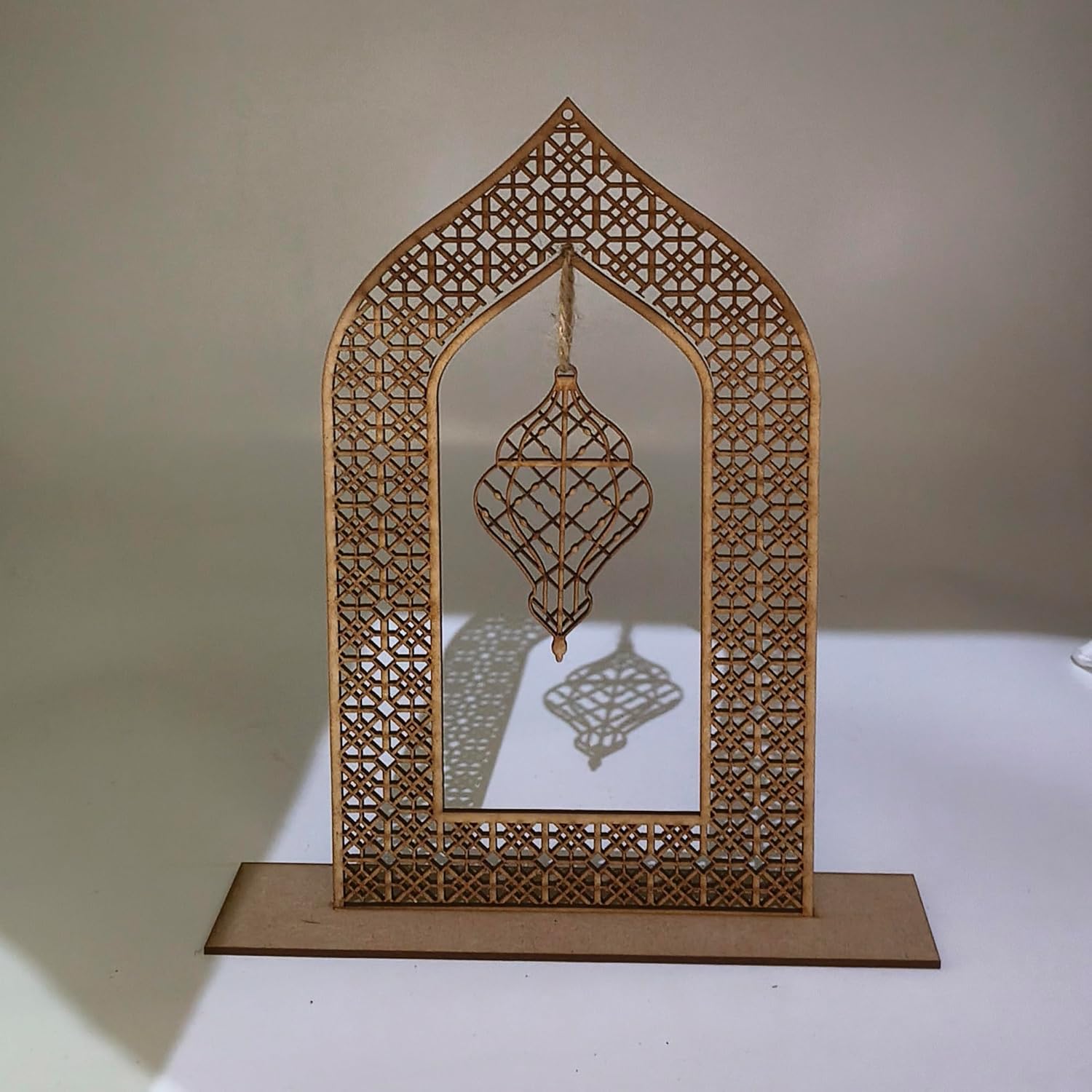 Decorative wooden arch with intricate cut-out patterns on a plain background