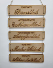 Wooden wall hanging with engraved phrases on a white background