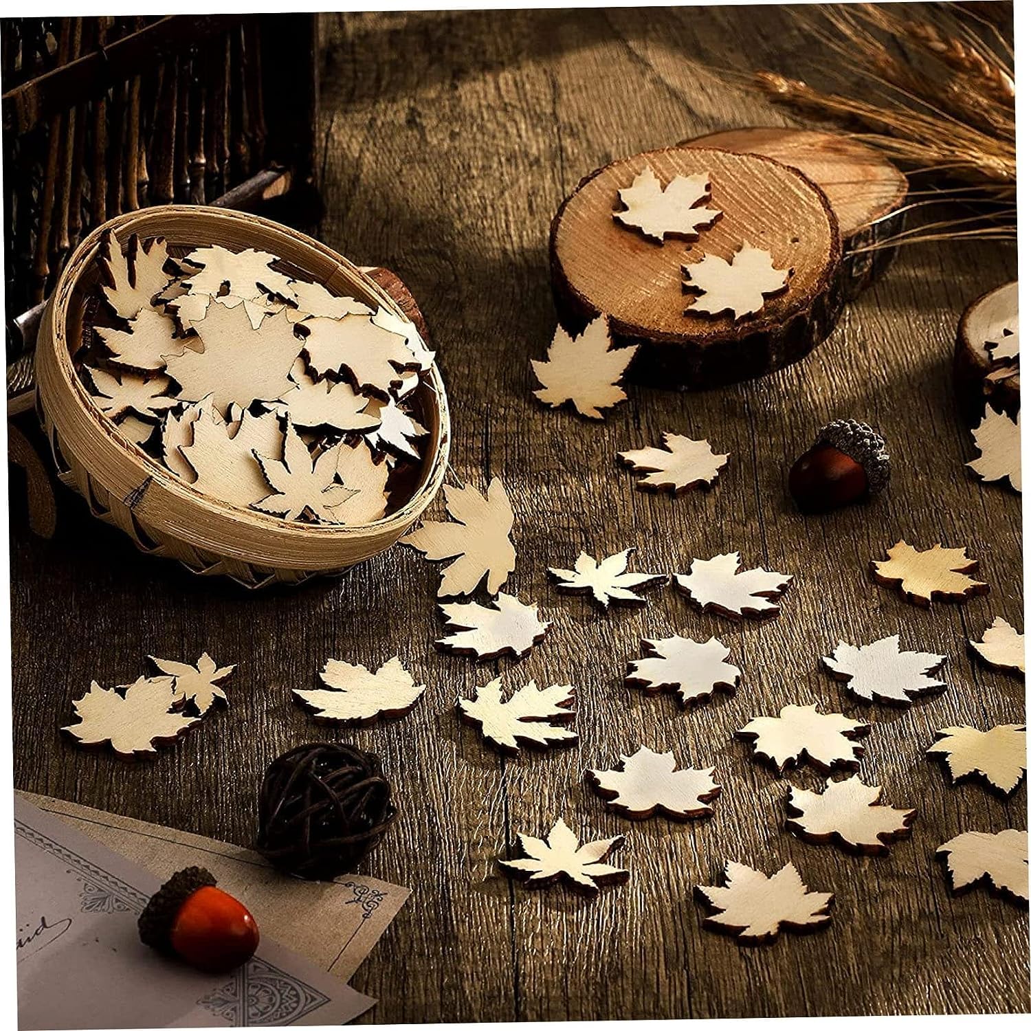 Wooden leaf decorations on a wooden surface with acorns and a basket.
