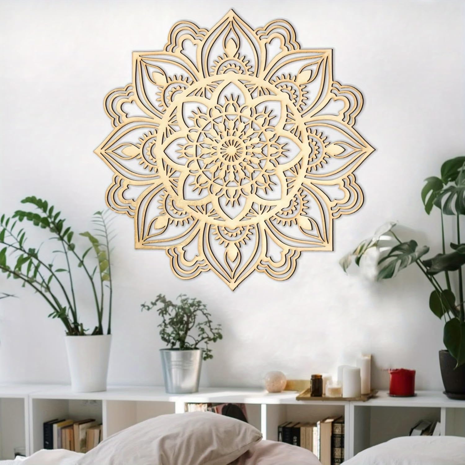 Decorative gold mandala wall art in a room with plants and shelves.