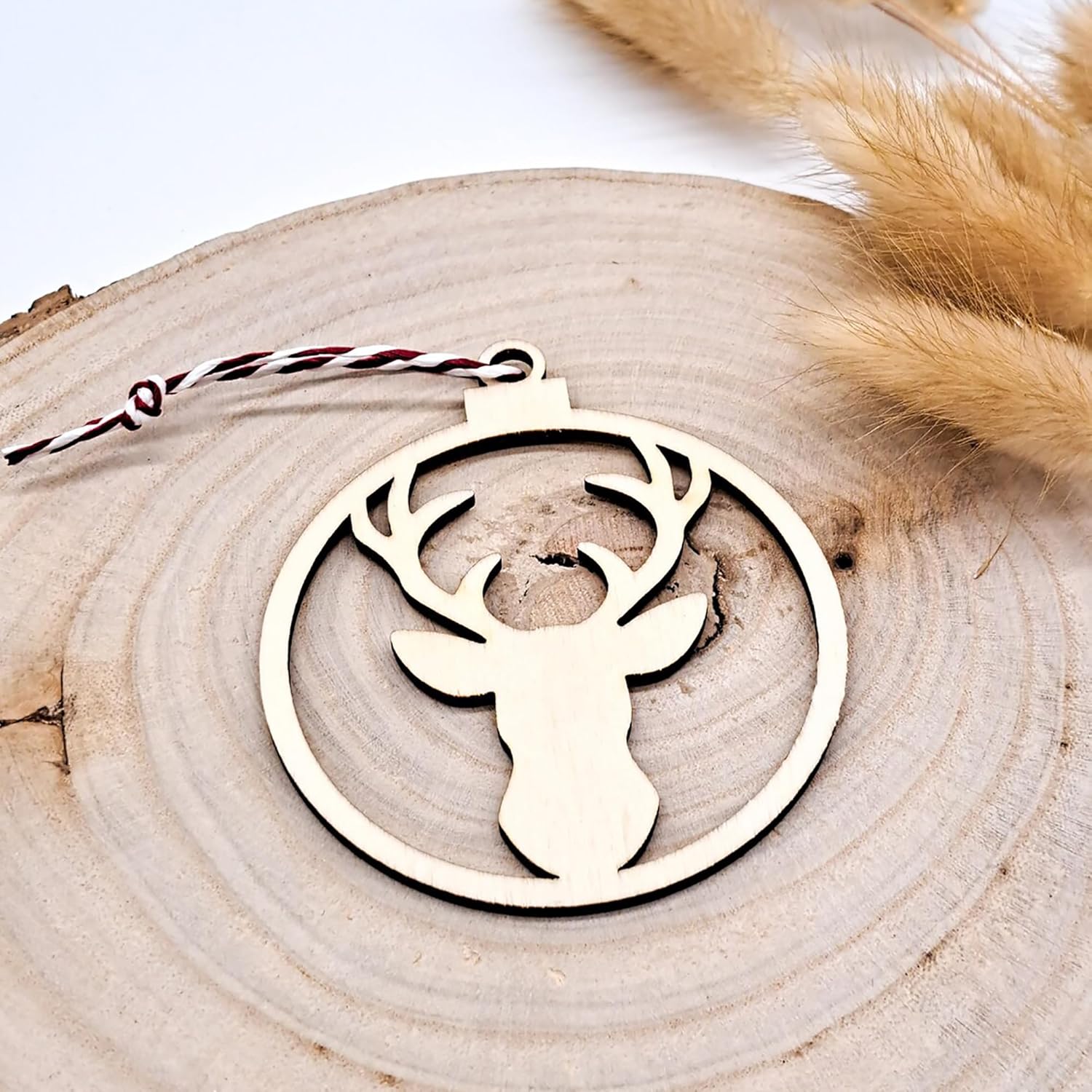 Wooden deer head ornament on a wooden surface with a blurred background
