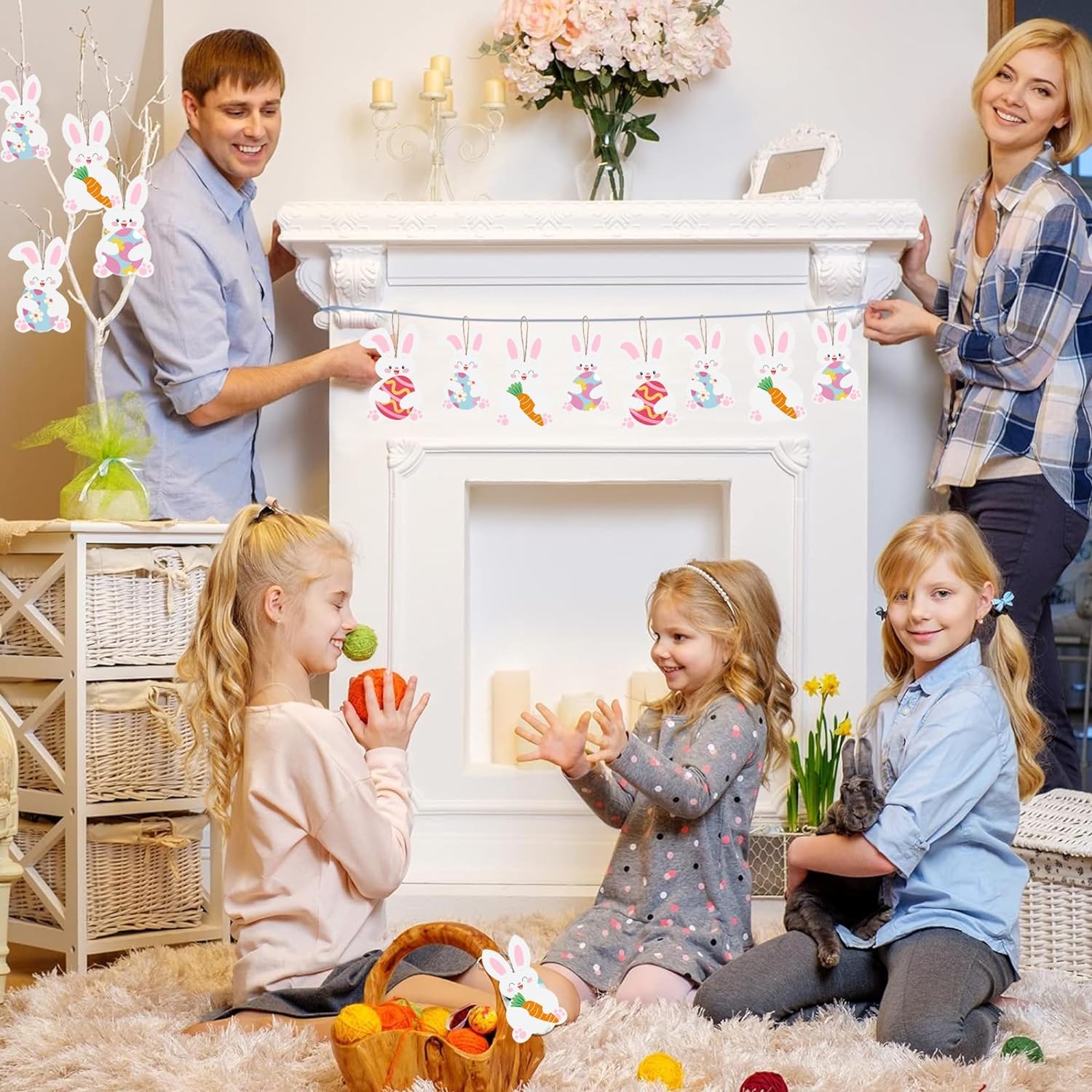 Family of four decorating a fireplace with Easter decorations in a cozy living room.