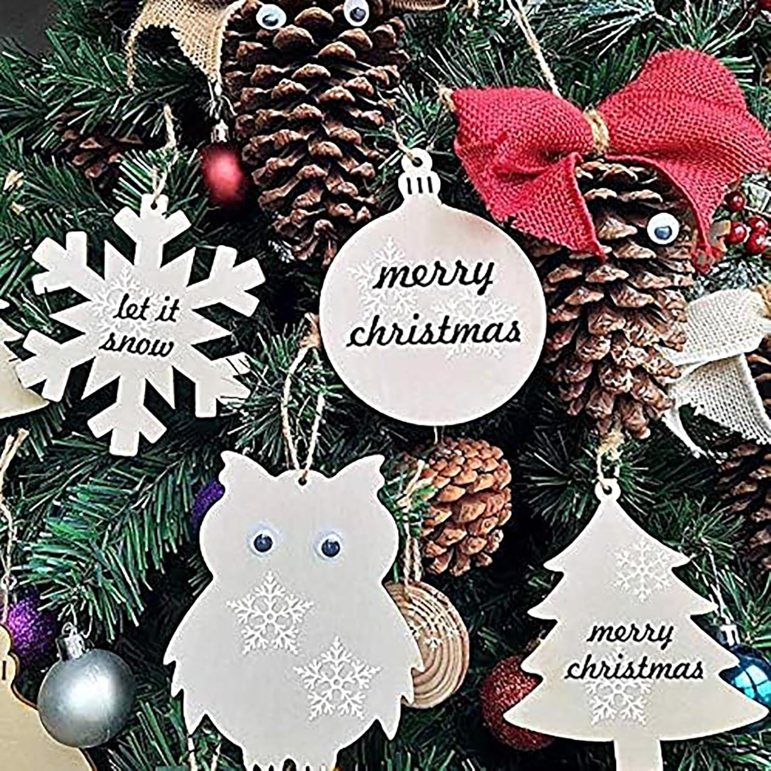 Decorative Christmas ornaments on a tree with pine cones and a red bow.