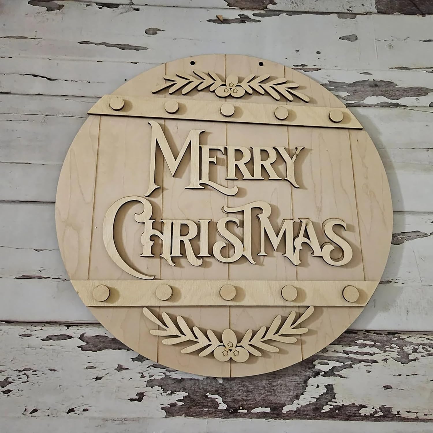Wooden 'Merry Christmas' sign with leaf designs on a rustic wooden background