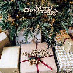 Decorated Christmas tree with wrapped gifts and 'Merry Christmas' ornaments.